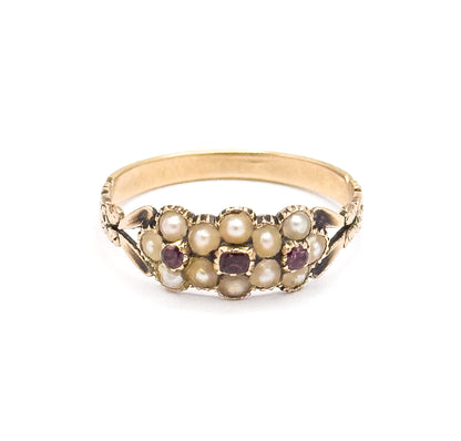 Upright front view against white, the face level with the camera so the split seed pearl flowers and three pinkish-purple tourmalines read across the setting above the plain band.