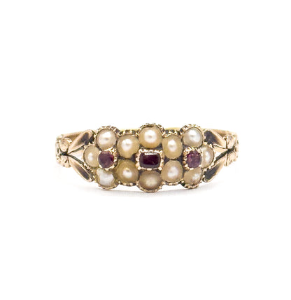 Close straight-on view of the face filling the frame, the crimped collets of seed pearls ranged around a rectangular tourmaline and two round ones, with carved leaf shoulders at either side.