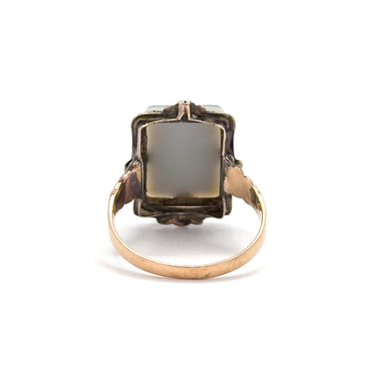 Straight-on from the back, the squared gallery frames the pale underside of the sardonyx, with the rosy-toned shoulders splaying outward and the smooth band curving down to a flat base.
