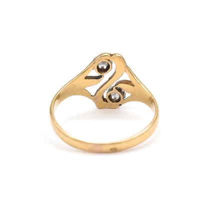 Rear view standing upright on white, the 18K yellow gold shank rising to the back of the openwork "S" face where the two diamonds show through their prong settings.