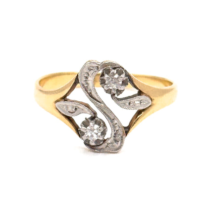 Almost the same view with slightly different angle, closer in so the two leaf-shaped openwork scrolls flanking the "S" read clearly, each tipped with a tiny milgrain-edged pierced eye.