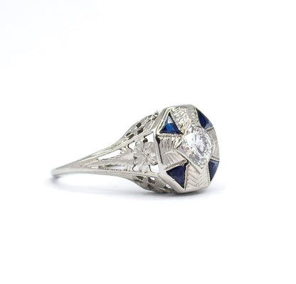 Side profile against white, showing how high the octagonal face sits above the pierced filigree gallery, with the shank tapering down from the etched shoulders.