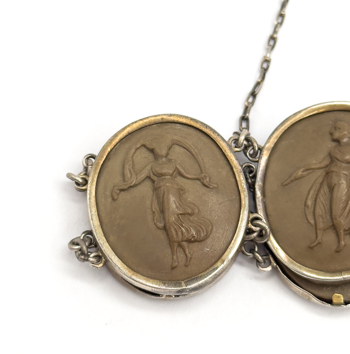 Tight close-up of one carved khaki-brown cameo of a draped dancing figure with a veil raised overhead, its bezel joined by double link rings to the next cameo, safety chain rising at the top.