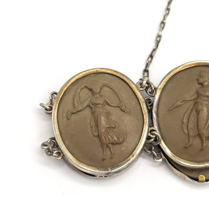 Tight close-up of one carved khaki-brown cameo of a draped dancing figure with a veil raised overhead, its bezel joined by double link rings to the next cameo, safety chain rising at the top.
