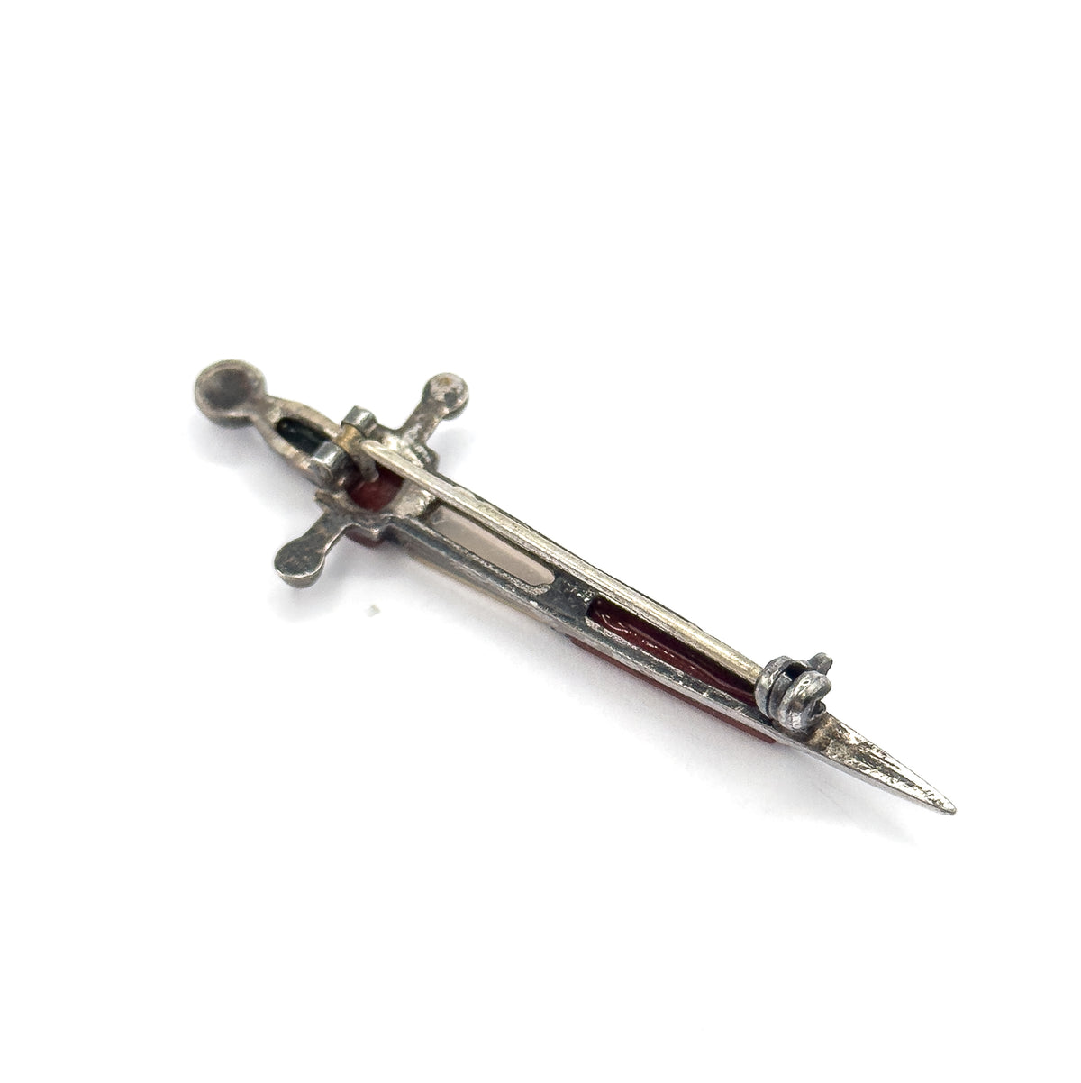 The reverse of the brooch on a plain white background, showing the long pin stem running the length of the blade into the hook catch near the tip.