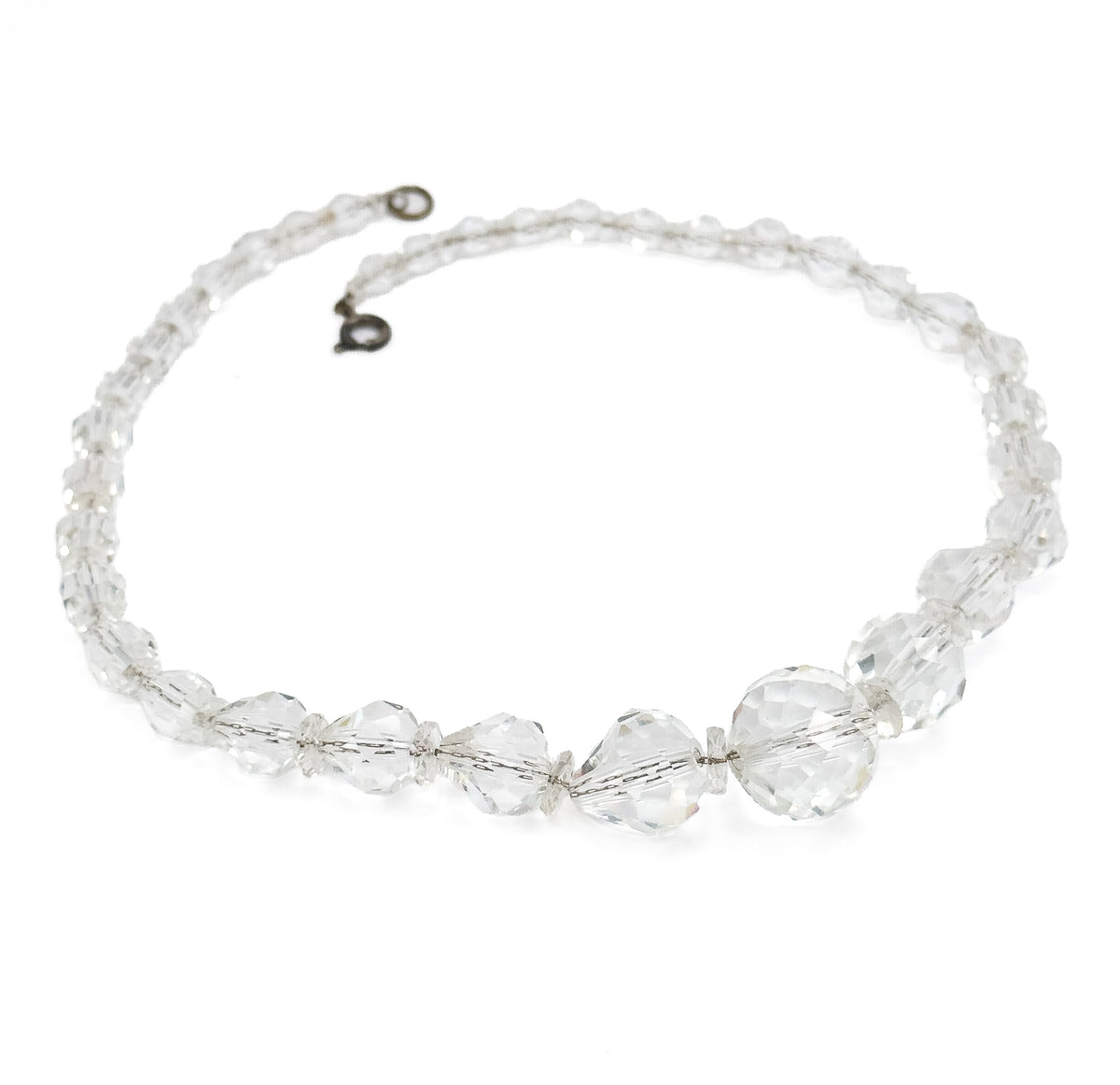 The whole necklace laid out in a full oval on white, the open clasp and small ring meeting at the top and the beads graduating from tiny near the clasp to large at the bottom.