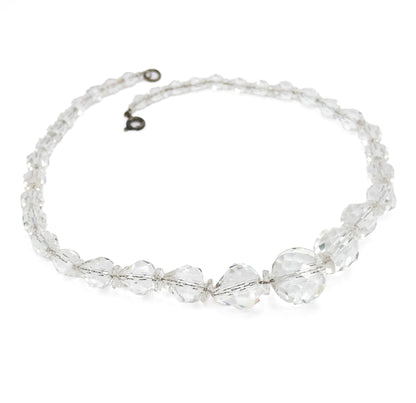 The whole necklace laid out in a full oval on white, the open clasp and small ring meeting at the top and the beads graduating from tiny near the clasp to large at the bottom.