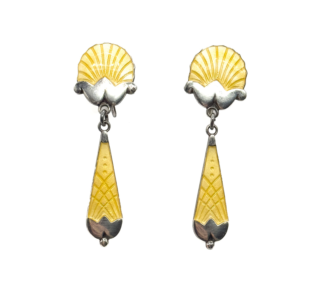 Both earrings stand upright and face-on against white, the fluted shells above and the drops showing a crosshatched lattice of yellow enamel ending in polished silver tips with tiny beads.