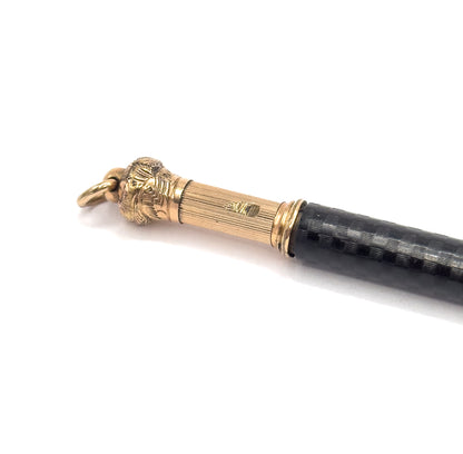 Close view of the upper end, showing the ribbed gold filled cap with its leafy chased collar, small stamped mark and the round jump ring at the tip.
