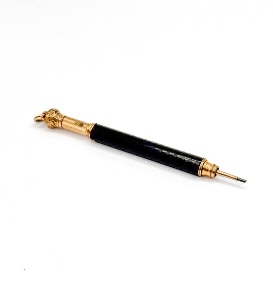 Victorian FAIRCHILD telescopic propelling pencil, its chased black hard rubber barrel set with gold filled cap, fittings and jump ring, shown lying diagonally on a plain white background.
