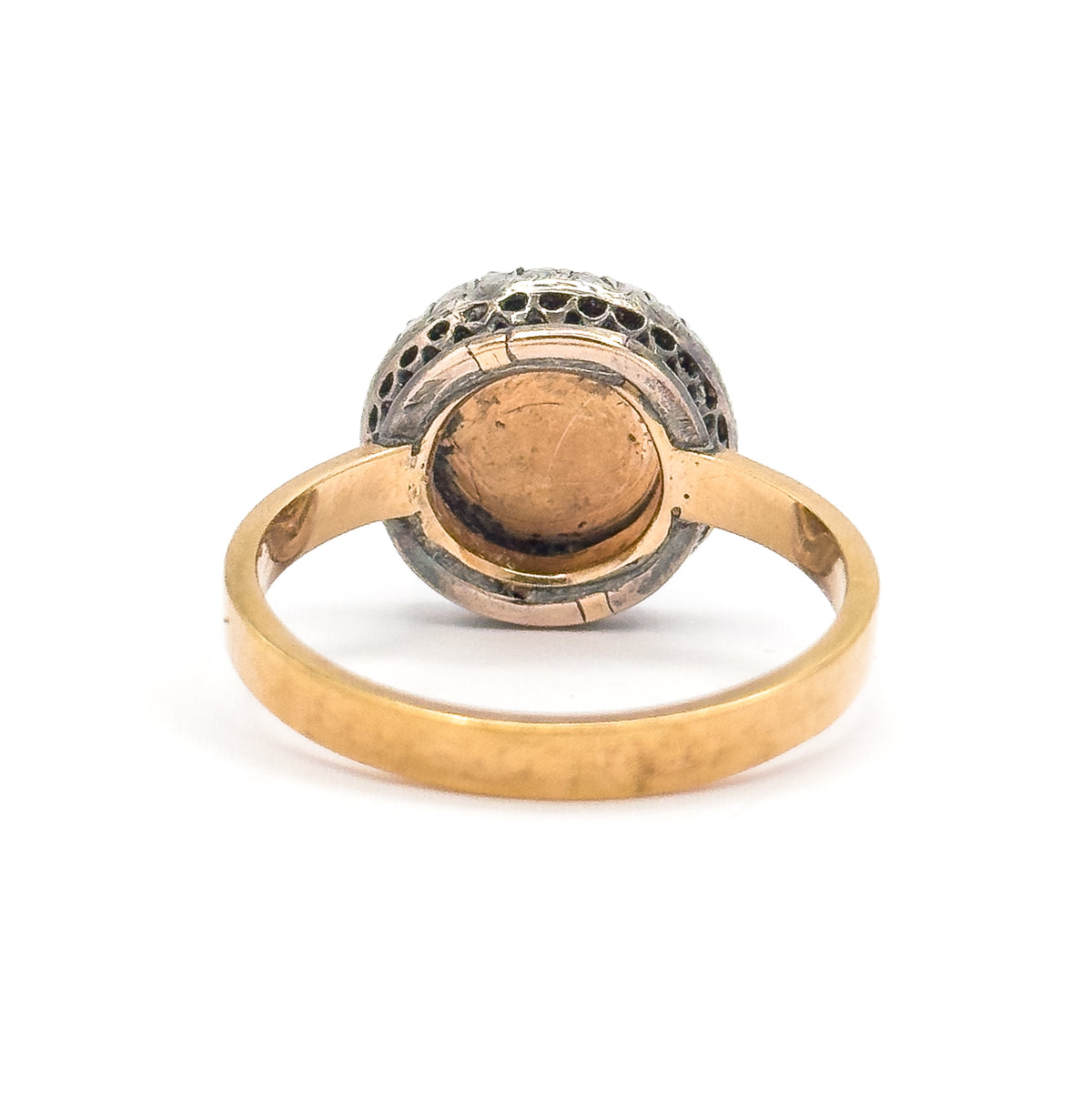 Closer back view on white, the rounded underside of the bezel filling the frame so the gold-rimmed crystal backing and the darker silver halo mount read clearly above the flat gold shank.