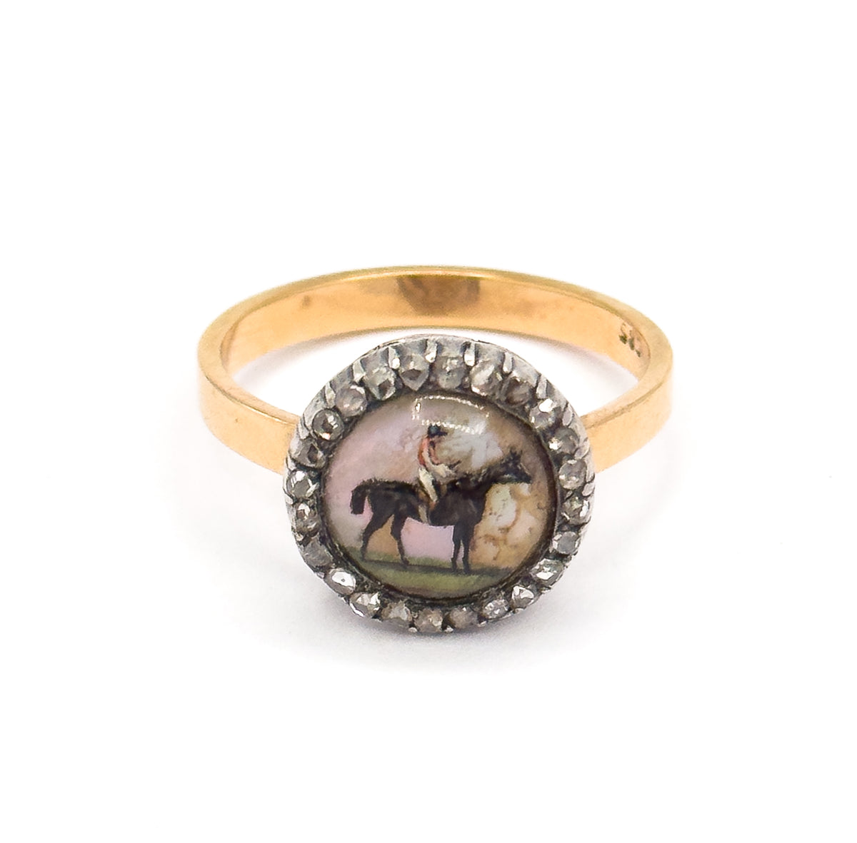 Upright front view on white with the ring standing on its band, the round Essex crystal and its silver-set diamond halo squarely centred and both shoulders of the yellow gold shank sweeping out evenly.