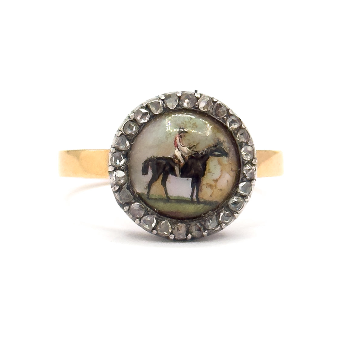 Closest crop yet, the Essex crystal filling the frame so the standing dark horse, its red-capped rider and the green ground show clearly, each rose cut diamond in the silver halo distinct.