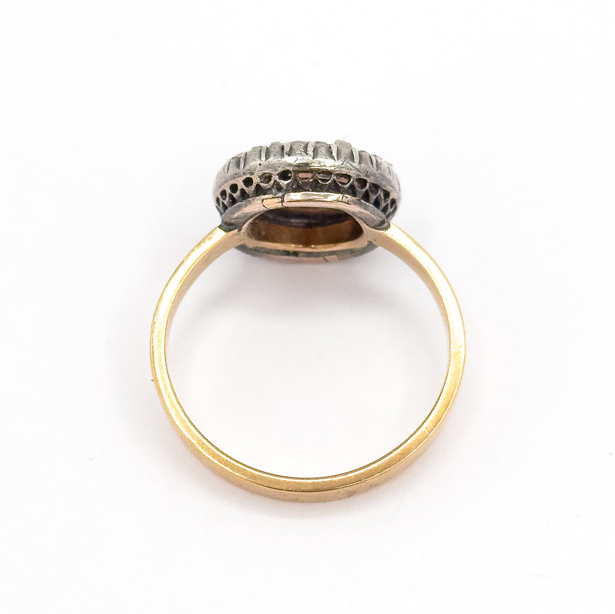 Back view on white, the ring standing upright so the open gallery beneath the bezel and the darker silver halo mount are seen from behind, with the slim gold shank forming a full circle.