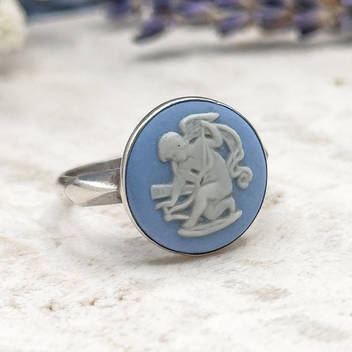 Decorative ring with blue and white design on a textured surface