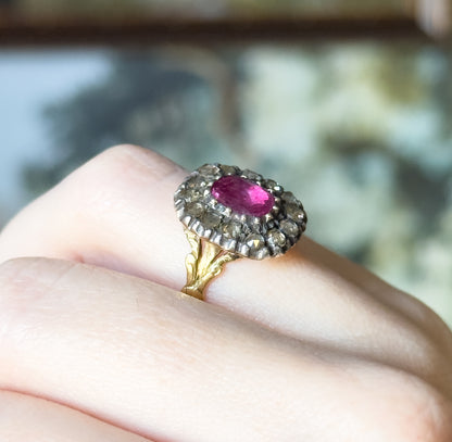 Shown on a finger at a low angle, this view reveals the ring's close profile, the foliate split shoulders and the tapering gold shank beneath the silver-set sapphire and diamond halo.