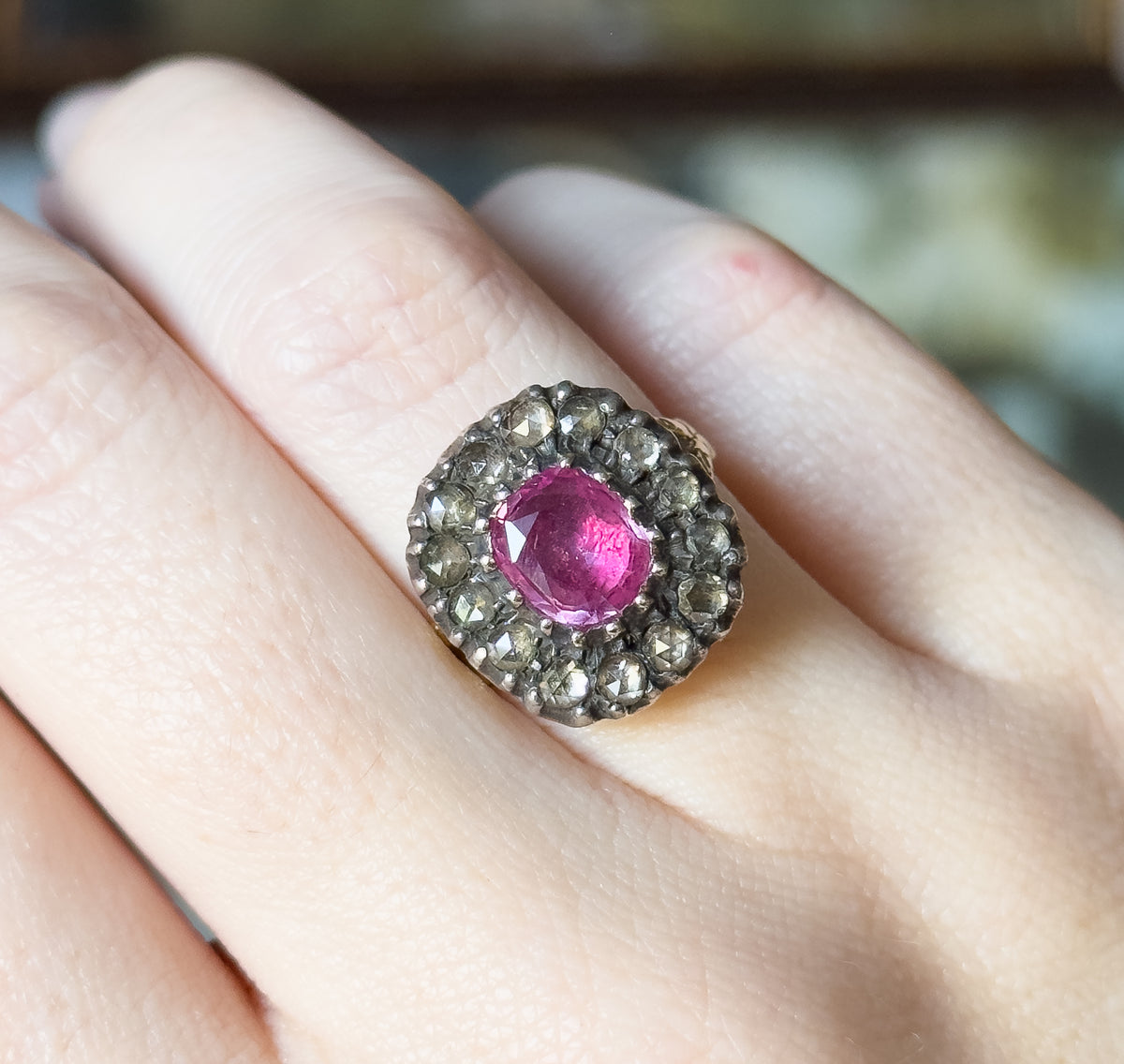 Shown on the finger across the frame, this view sets the ring's scalloped silver halo edge against the skin, giving a clear sense of how little of the finger's width the face covers.