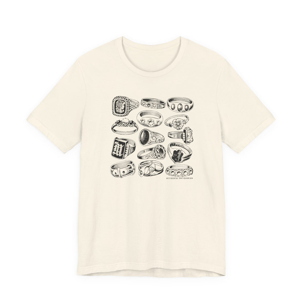 Cream tee laid flat on a plain white background with no model, showing the whole front: crew neck, short sleeves, and the full grid of drawn rings with the small "Accidental Antiquarian" line beneath.