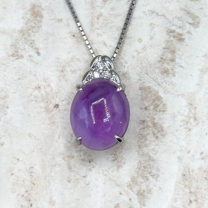 Purple pendant necklace on a textured white surface