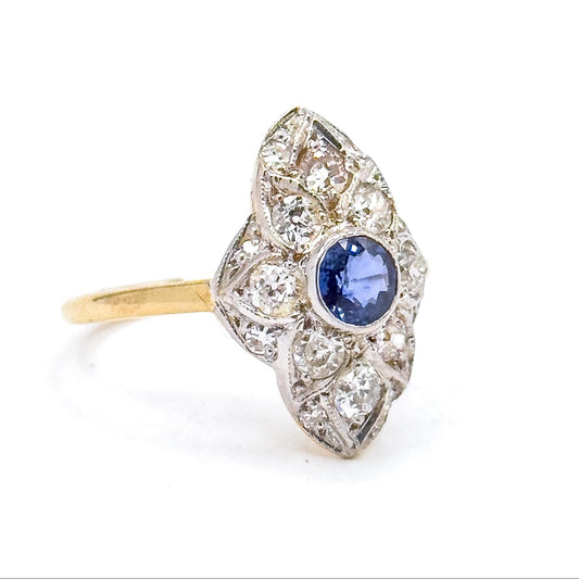 Ring with a blue gemstone and diamond accents on a white background
