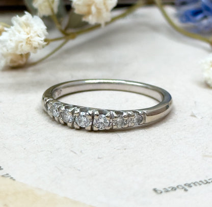 Silver ring with diamonds on a light background with flowers