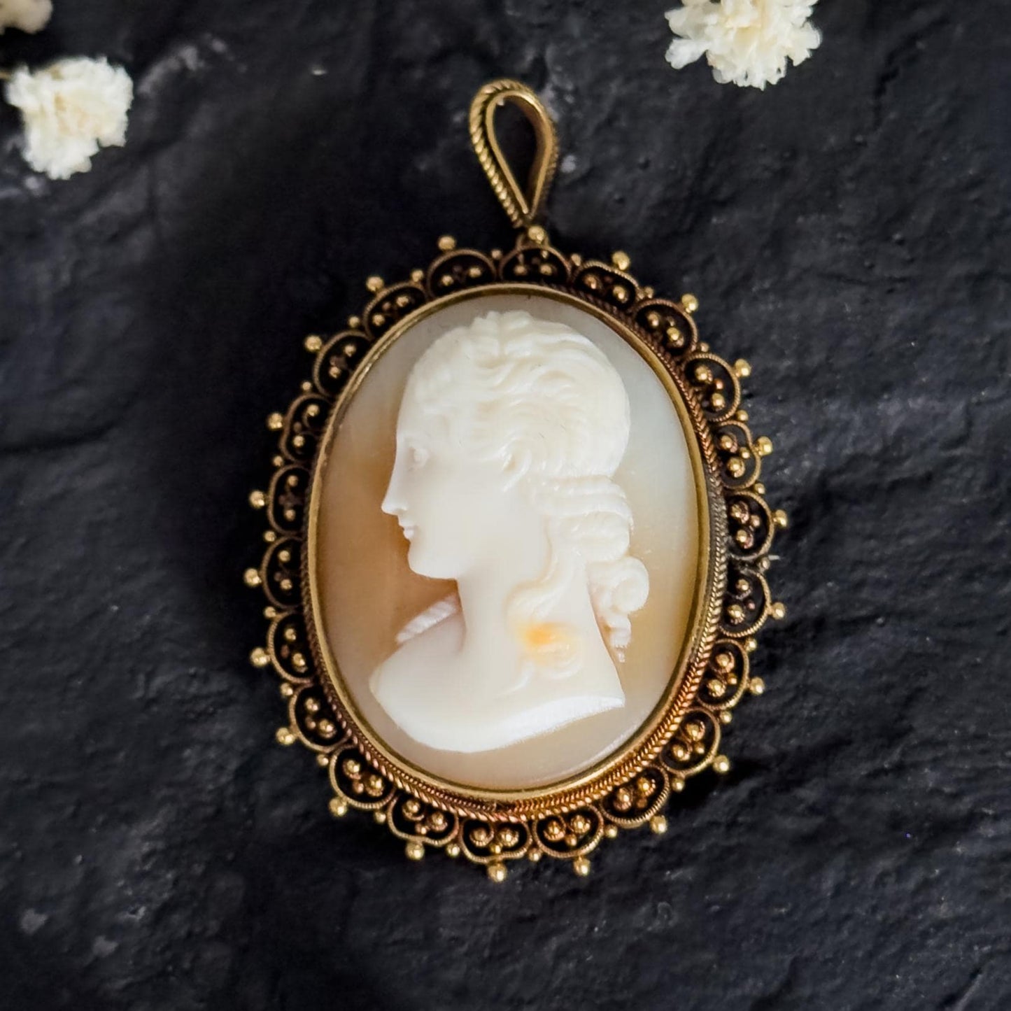 antique solid gold cameo on black stone surface