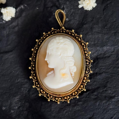 antique solid gold cameo on black stone surface