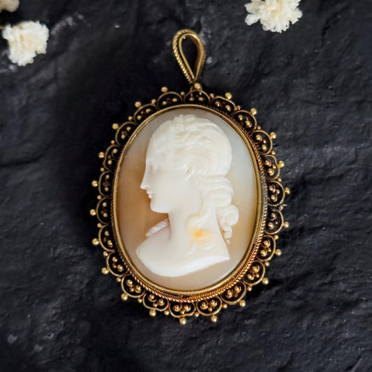 antique solid gold cameo on black stone surface