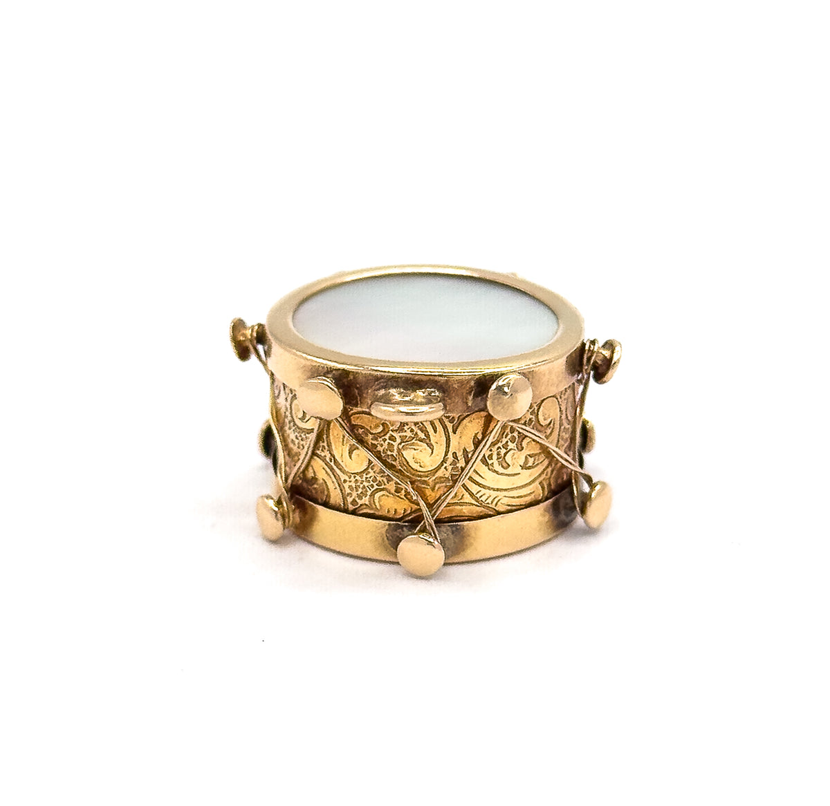 Viewed nearly side-on so the drum's depth and rosy engraved band fill the frame, with the mother of pearl face a narrow ellipse along the top rim.