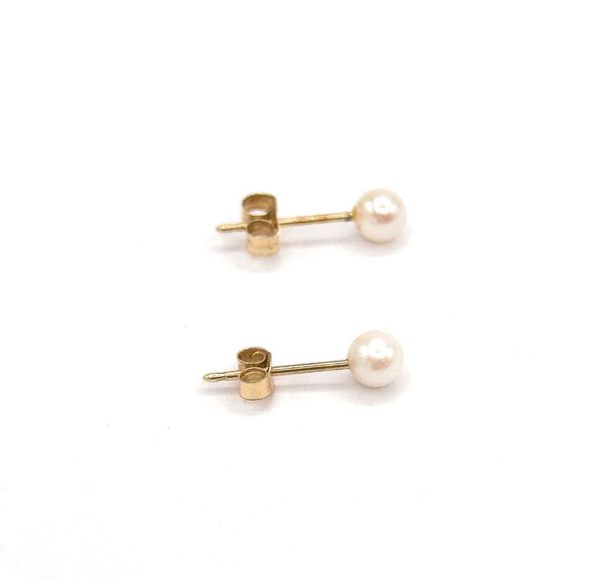 Both studs seen from the side, each round white pearl at the end of a straight yellow gold post with its butterfly back slid partway along.