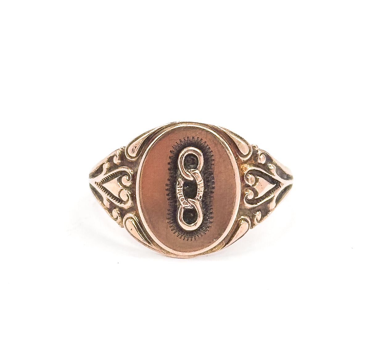 Almost the same view with slightly different angle, the whole ring standing upright and smaller in the frame so the heart-shaped openwork shoulders and narrowing shank read clearly.