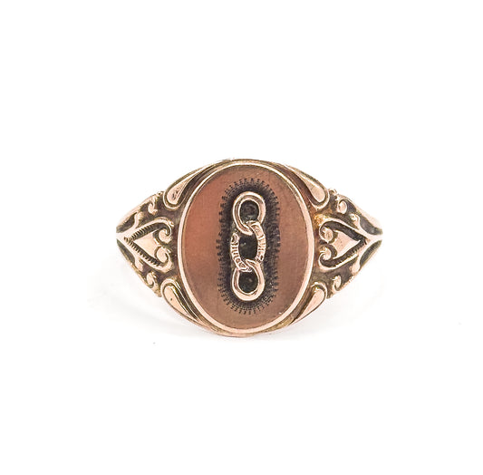 Almost the same view with slightly different angle, the whole ring standing upright and smaller in the frame so the heart-shaped openwork shoulders and narrowing shank read clearly.