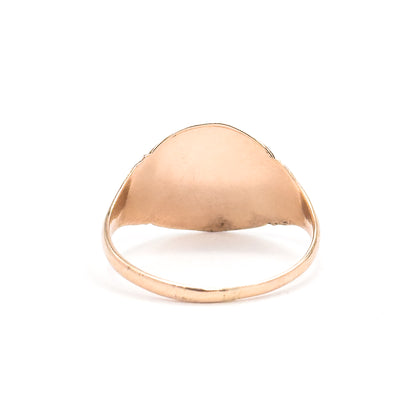 Closer view from the back, filling the frame with the plain smooth underside of the oval face and the slim shank sweeping down into a rounded base.