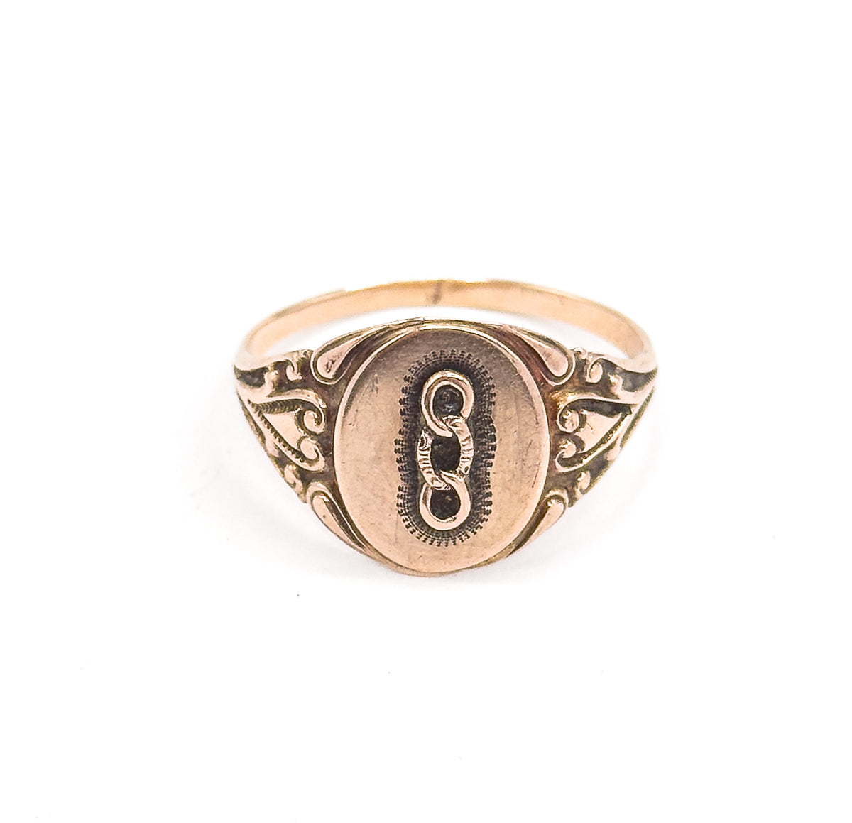 Fully face-on and upright, the oval face sits centred with the three-link emblem and stippled border, flanked by matching scrolled shoulders rising from the slim yellow gold shank.