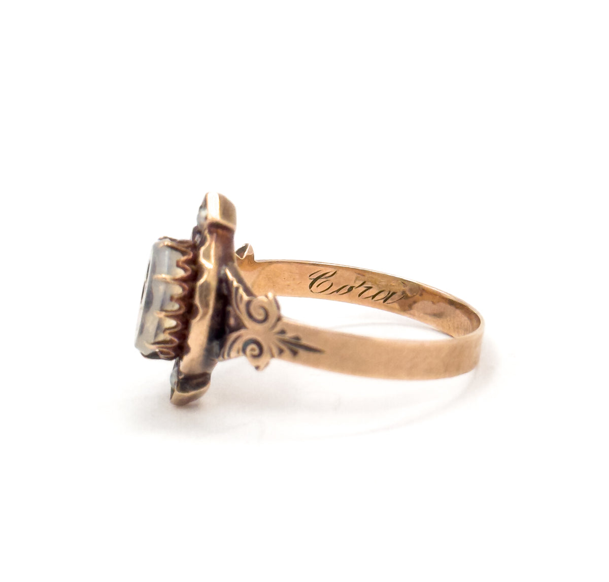 Side view against white with the shank's interior turned to the lens so the flowing script inscription "Cora" is legible, beside the prongs gripping the face and the engraved shoulder.
