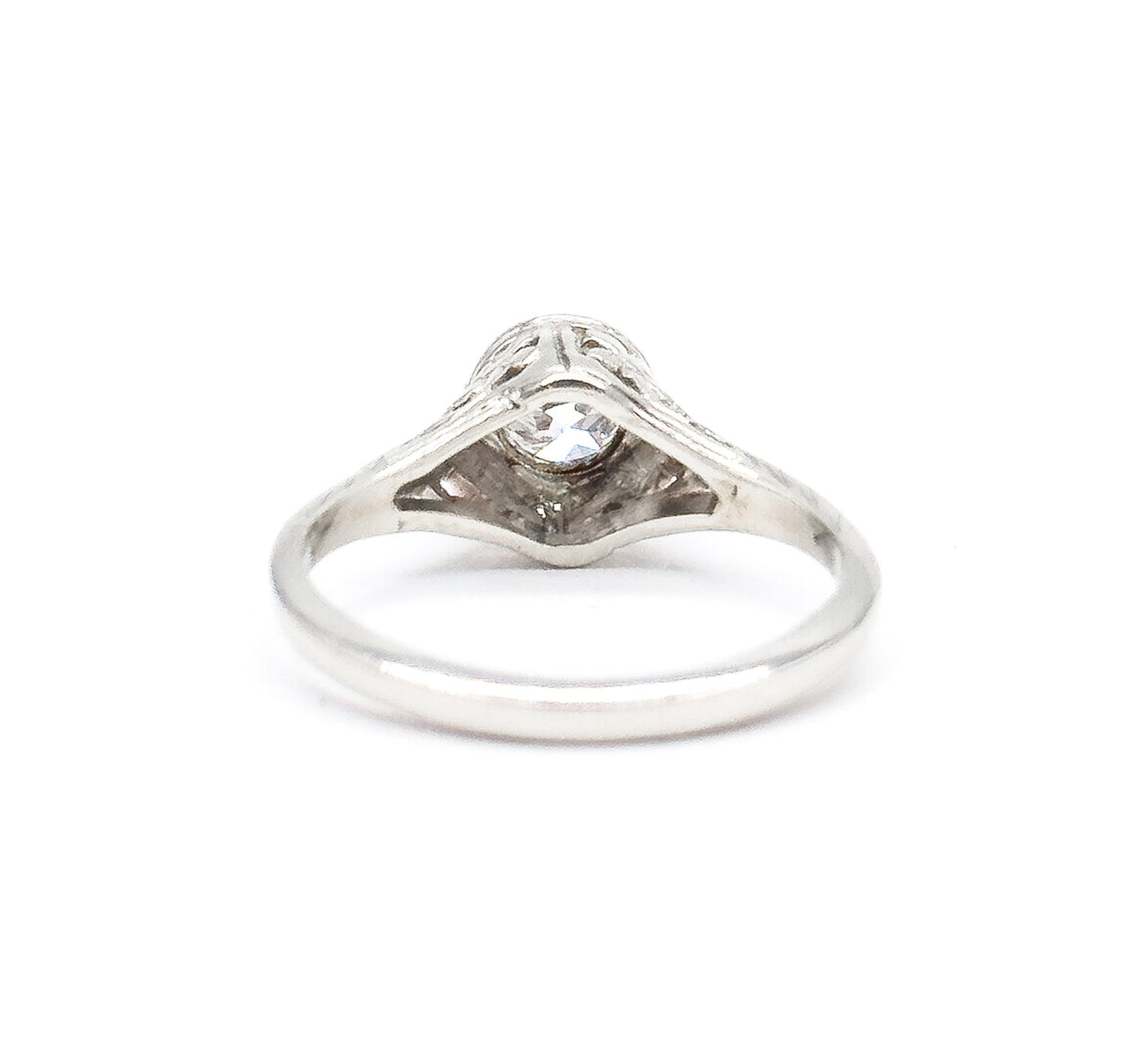 Rear view with the ring upright, looking through the open shank at the pointed underside of the gallery and the back of the diamond seated in its bezel, the plain band smooth across the bottom.