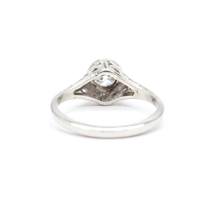 Rear view with the ring upright, looking through the open shank at the pointed underside of the gallery and the back of the diamond seated in its bezel, the plain band smooth across the bottom.