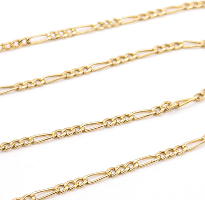 Magnified detail of three parallel rows of the 14 karat yellow gold chain on white, showing the polished alternating pattern of two short round links to one long oval link.