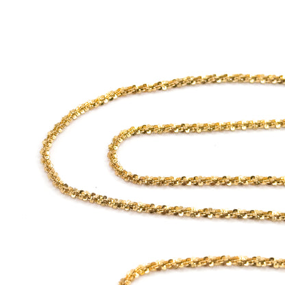 The chain coiled in long looping rows across a white background, each curve catching light so the faceted popcorn links sparkle along their full 18-inch run.