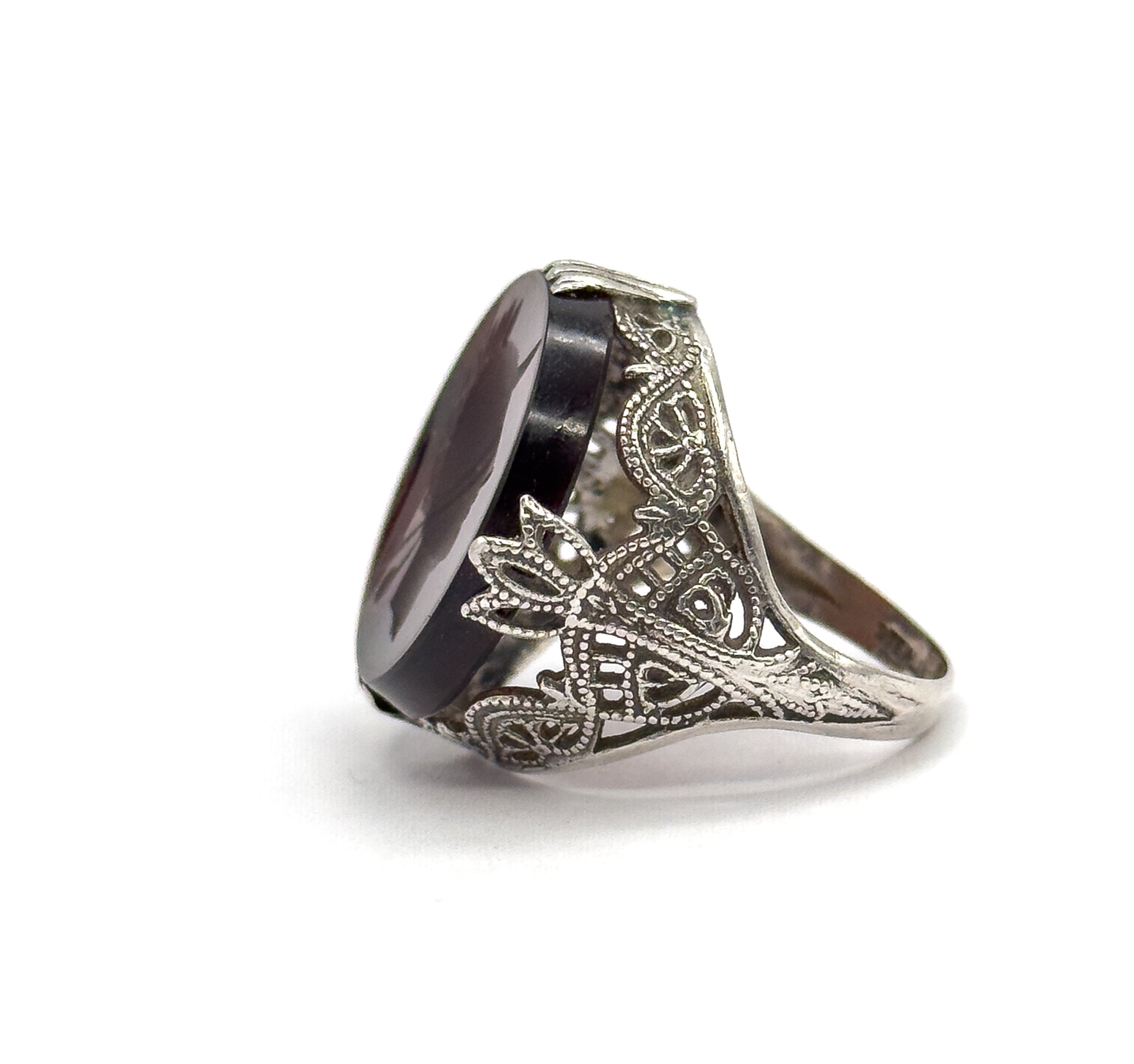 Near-side view against white with the stone turned away, emphasising the thickness of the rootbeer quartz rim gripped by prongs and the filigree shoulders flaring out above the slim shank.