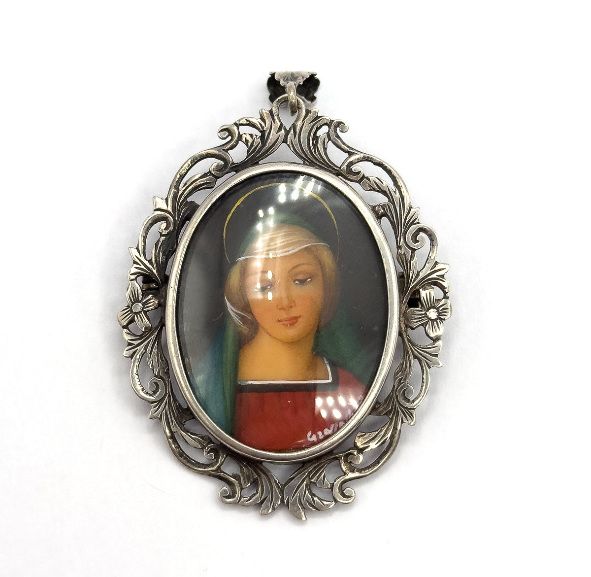 Straight-on and filling the frame, the portrait shows the green veil, red robe, painted halo ring and small signature at lower right, ringed by the acanthus and flower openwork frame.