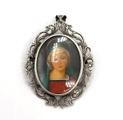 Straight-on and filling the frame, the portrait shows the green veil, red robe, painted halo ring and small signature at lower right, ringed by the acanthus and flower openwork frame.