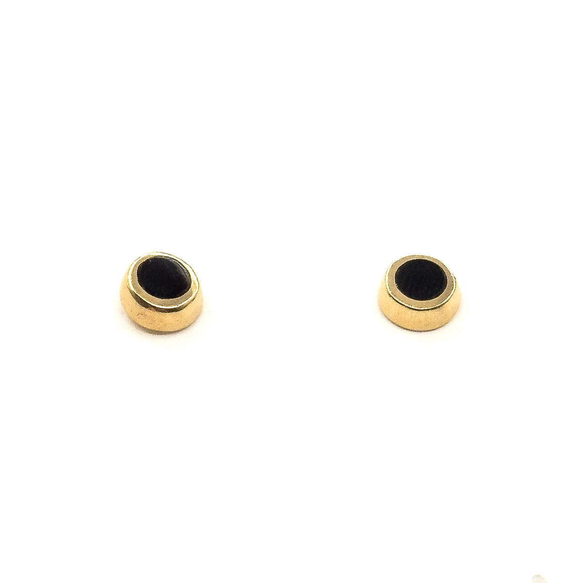 The pair stands upright on white, tilted so the rounded yellow gold side walls and the depth of each bezel are visible beneath the black enamel faces.