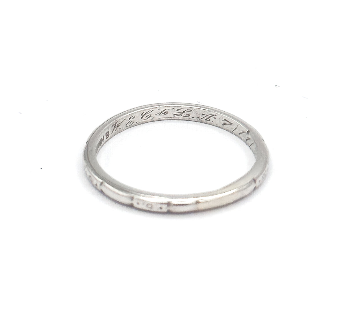 Viewed from above with the hoop lying almost flat, the inner back shows the maker's stamp ahead of the script inscription, while the near rim's etched panels run along the lower edge.