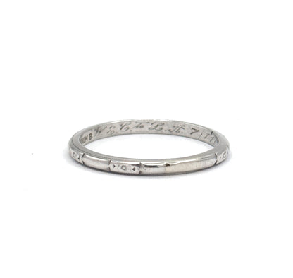 Standing upright against plain white, the band shows its full circle with the stamp and inscription across the inner far wall and a tiny sunburst motif centred in a panel on the near lower rim.