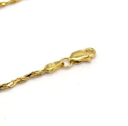 Diagonal close view of the lobster clasp closed onto the ring at the stamped end tag, with the crinkle chain trailing off to the lower left across white.