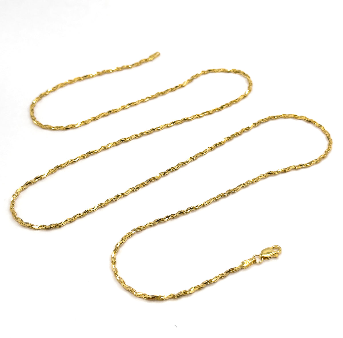 The whole chain laid out in three long serpentine loops on white, showing its full length at once with the lobster clasp and end tag resting at the lower right.