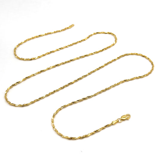 The whole chain laid out in three long serpentine loops on white, showing its full length at once with the lobster clasp and end tag resting at the lower right.