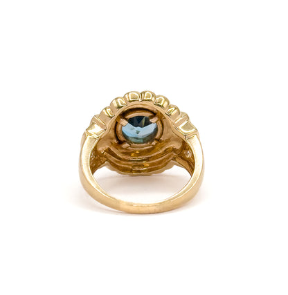Seen from behind and below, the open shank curving up to the hollowed underside of the gallery, with the back of the blue topaz visible through the bezel opening.