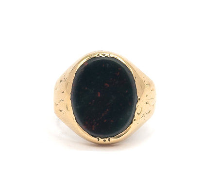 Straight-on front view with the oval bloodstone filling the bezel, dark green with red speckles, flanked by engraved yellow gold shoulders tapering down to the shank.